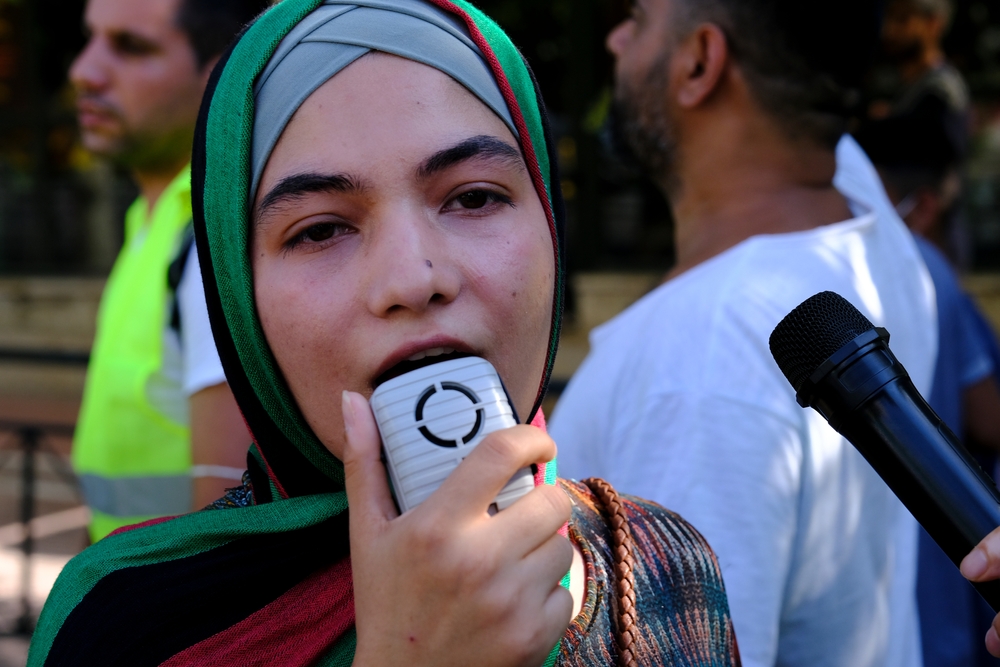 Refugee woman using a loudspeaker
