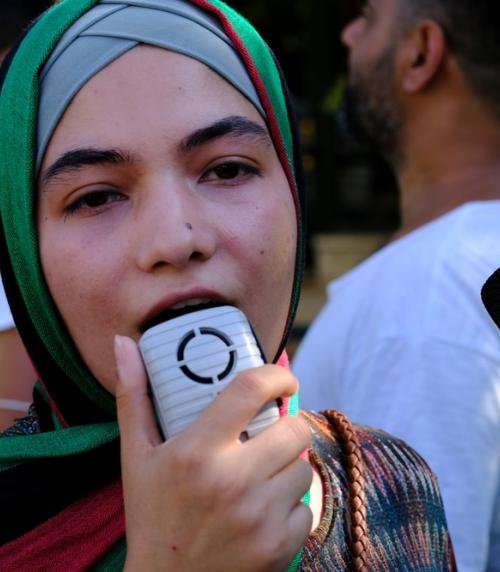 A refugee woman with a loudspeaker